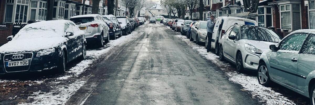 cars parked on road in the snow