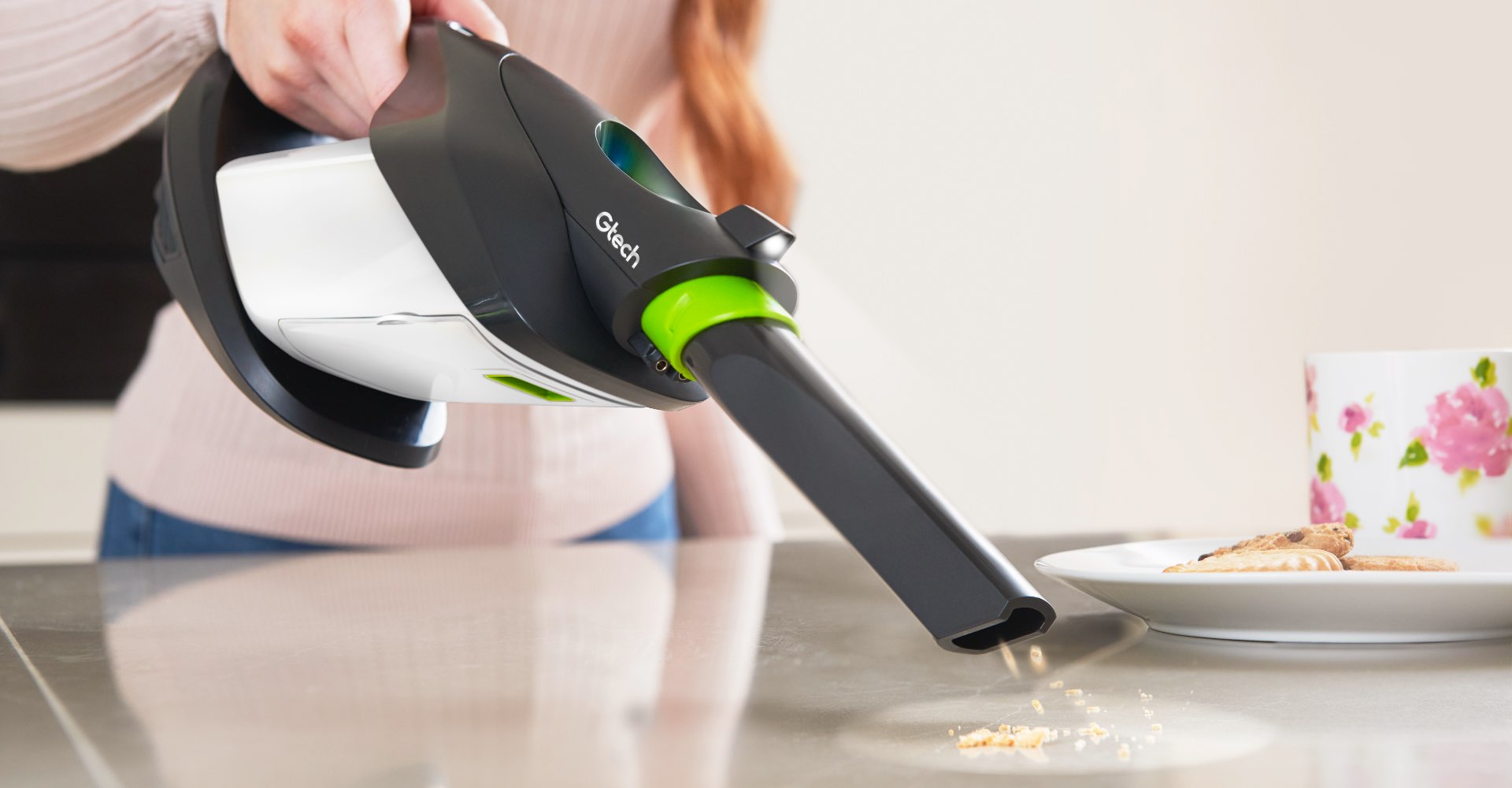 Woman using ProLite handheld vacuum to clean crumbs on worktop