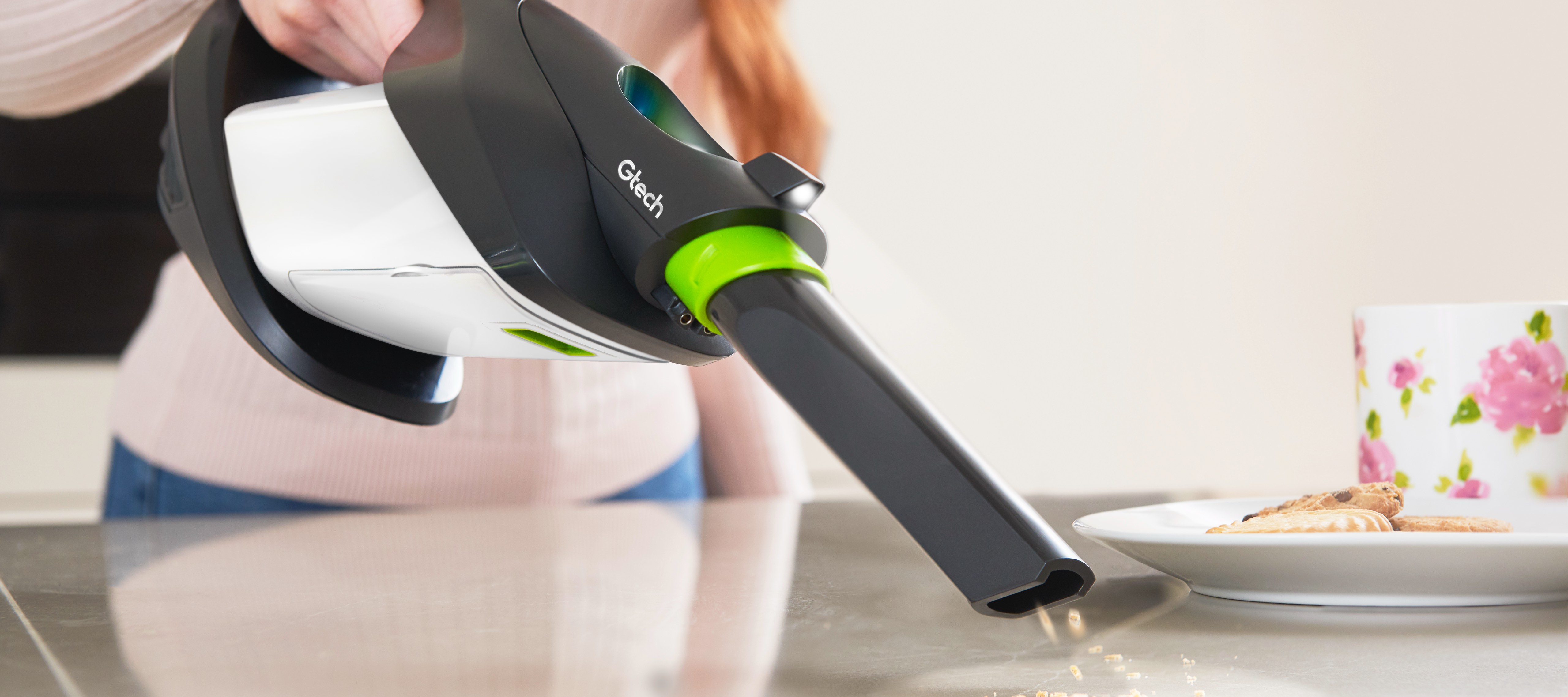 Woman using ProLite handheld vacuum to clean crumbs on worktop